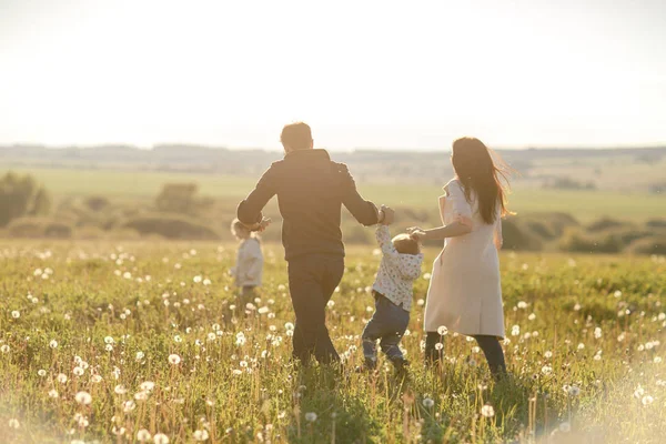 Щаслива молода сім'я проводить час на відкритому повітрі в літній день — стокове фото