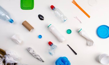 Beyaz arka planda bir dizi plastik atık, düz bir zemin. Plastik atık geri dönüşümünün konsept koleksiyonu. Pankart