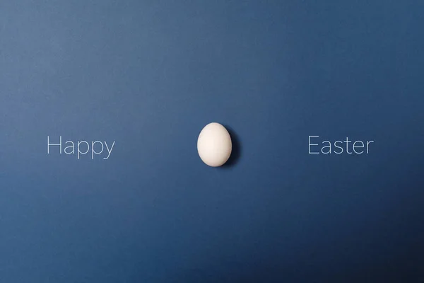 白色的复活节彩蛋,带着愉快的东方词,节日的概念. 蓝色背景。 顶部视图 — 图库照片
