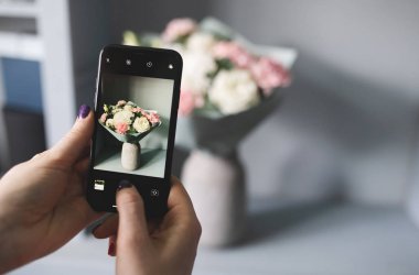 Blogcu bir buket çiçeğin fotoğrafını çekiyor
