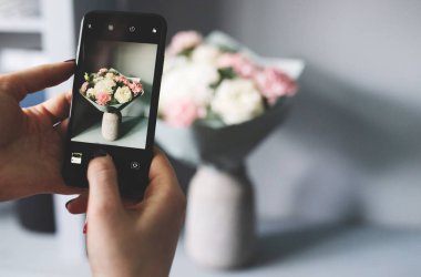 Blogcu bir buket çiçeğin fotoğrafını çekiyor