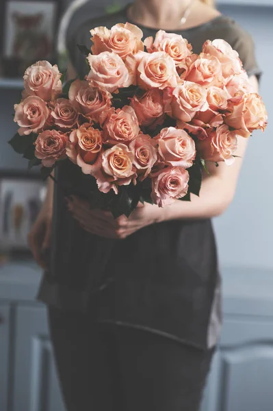 Яскраво-рожеві кущові троянди в жіночих руках — стокове фото