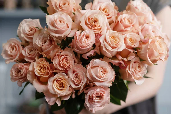 Rosas en aerosol rosa brillante en manos femeninas — Foto de Stock