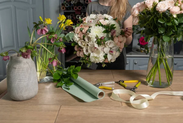 Bonito ramo fresco. Entrega de flores. Mujer florista crear arreglo floral en una canasta de mimbre. Hermoso ramo de flores mixtas. Concepto de tienda floral . —  Fotos de Stock