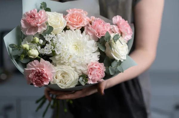 Närbild blommor i handen. Florist arbetsplatsen. Kvinna att arrangera en bukett med rosor, krysantemum, nejlika och andra blommor. En lärare i blomsterhandlare i mästarkurser eller kurser — Stockfoto