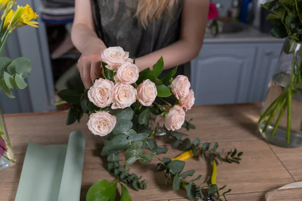 Florist flicka gör en bukett. Blomsteraffär. — Stockfoto