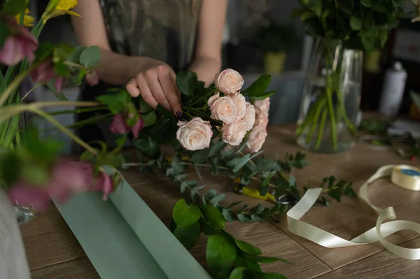 Florist flicka gör en bukett. Blomsteraffär. — Stockfoto