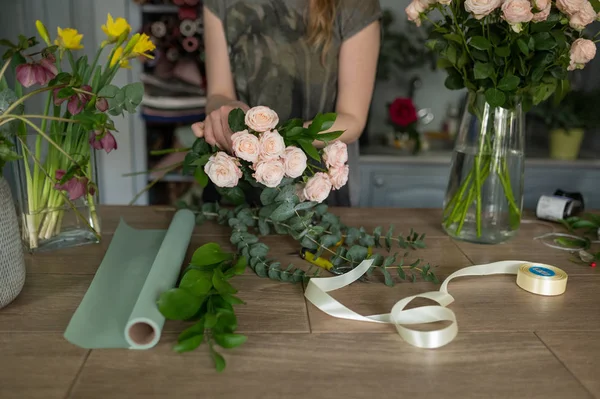 Bloemist meisje maakt een boeket. Bloemenwinkel. — Stockfoto