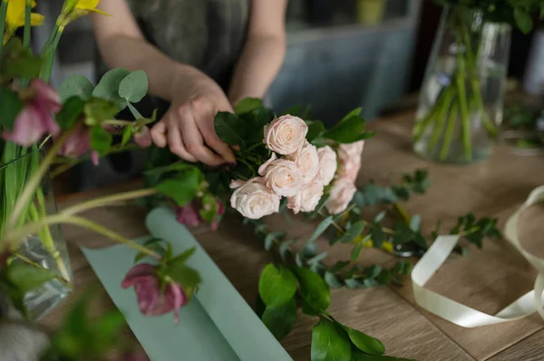 Florist flicka gör en bukett. Blomsteraffär. — Stockfoto