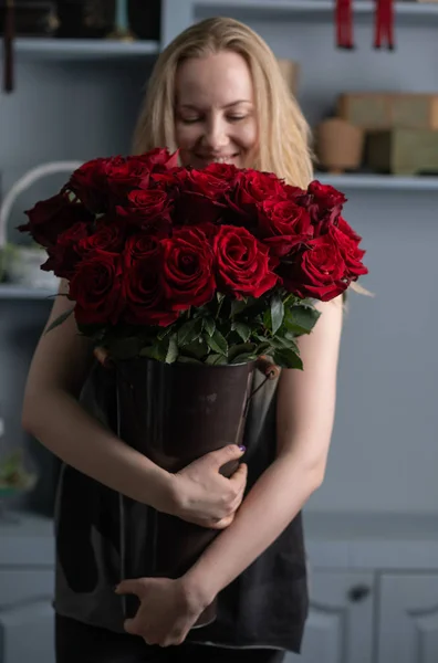 Mädchen mit einem riesigen Strauß roter Rosen in der Hand — Stockfoto