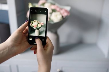 Blogcu bir buket çiçeğin fotoğrafını çekiyor