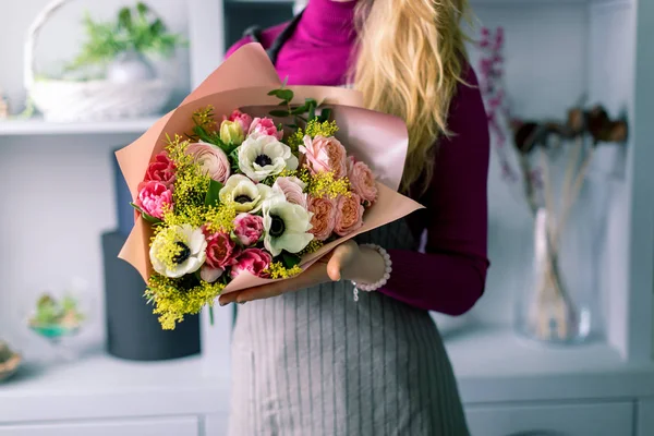 Florista segurando um buquê. Lindas flores de primavera. Arranjo com flores de mistura. O conceito de uma loja de flores, um pequeno negócio familiar. florista de trabalho. espaço de cópia — Fotografia de Stock