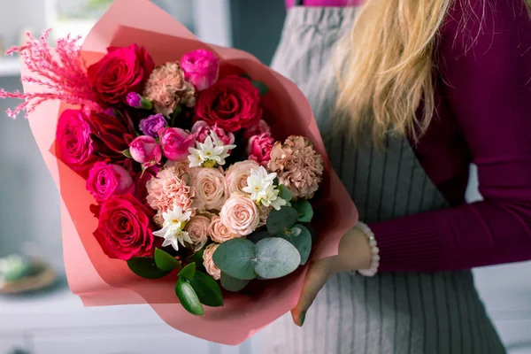 Rottöne Schöner Strauß gemischter Blumen in Frauenhänden. die Arbeit des Blumenhändlers in einem Blumenladen. Schöner frischer Strauß. Blumenlieferung. — Stockfoto
