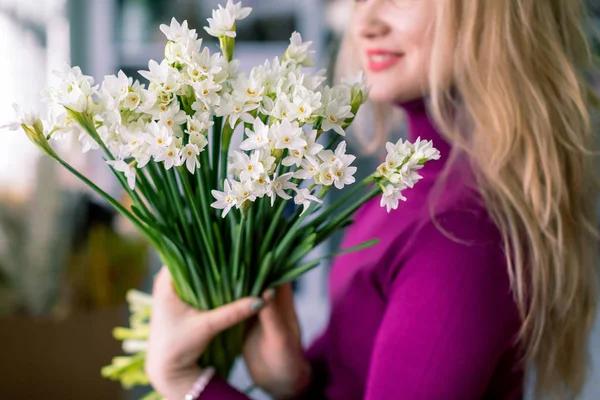 Una florista sosteniendo un ramo de narcisos. Tienda de flores —  Fotos de Stock