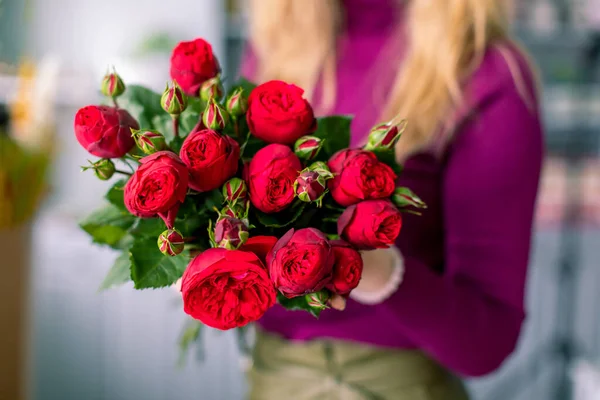 Vrouwelijke bloemist met boeket van rode rozen. Op Valentijnsdag vakantie — Stockfoto