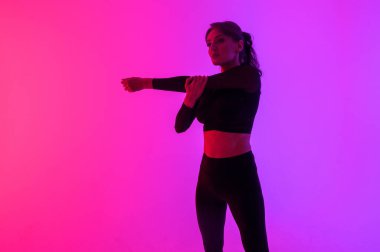  Parlak arka plandaki genç sporcu antrenmandan önce esneme hareketleri yapıyor