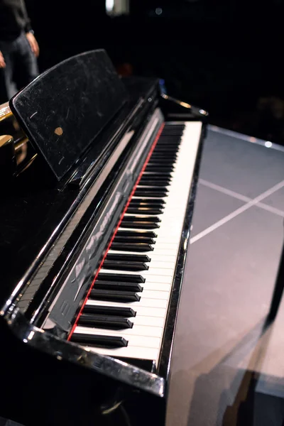 Piano negro en el escenario. piano de cola en el escenario antes de la actuación —  Fotos de Stock