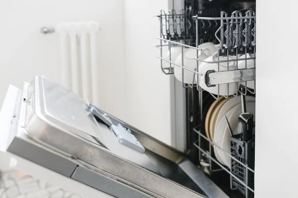 Открытая посудомоечная машина с чистой посудой на домашней кухне — стоковое фото