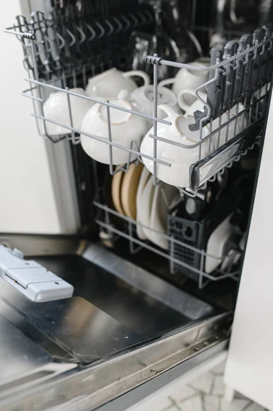 Открытая посудомоечная машина с чистым стеклом и посудой, избирательный фокус — стоковое фото