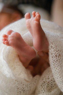 Yeni doğmuş bebek beyaz bir battaniyenin üzerinde - küçük bebek ayakları yakın plan. Yeni doğmuş tebrik kartı kavramı