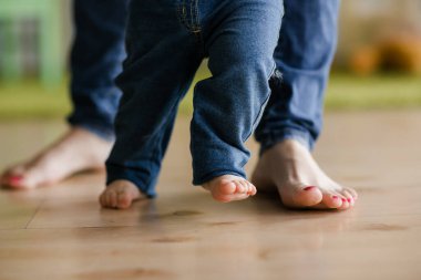 Bebeğin annelerle ilk adımı atması evde yardımcı olur. Mutlu aile kavramı