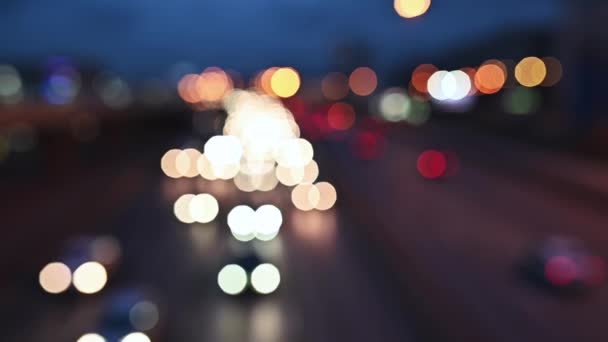 Bellissimo bokeh scintillante in sfondo scuro sfocato di notte. Il bokeh colorato rotondo brilla da semafori auto in ingorgo su strada di città. Fuori fuoco con sfocatura . — Video Stock