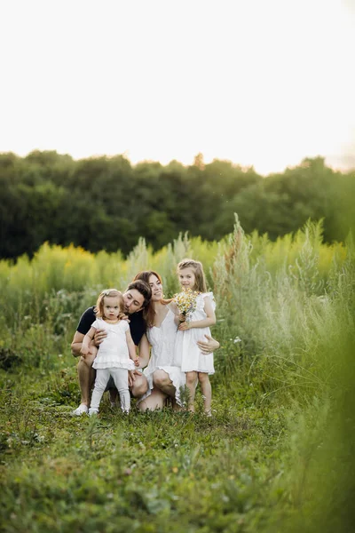 Šťastný muž a žena hrají s dětmi venku — Stock fotografie