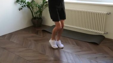 Yakışıklı sporcu evde tek başına ip atlama eğitimi alıyor. Fiziksel aktiviteden zevk alıyor. Halk, spor ve iç mekan kavramı