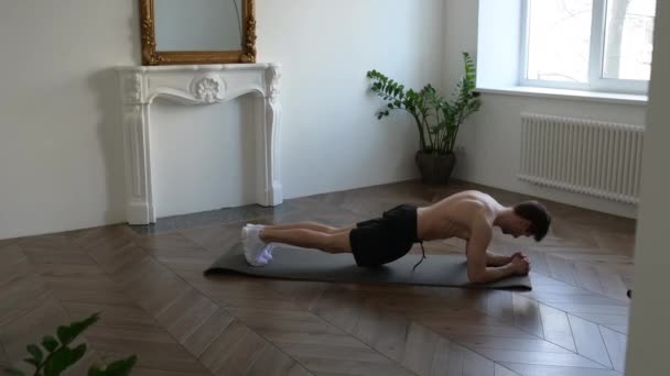 Sport homme faisant de l'exercice de planche, séance d'entraînement de fitness à la salle de gym. Athlète masculin noir avec corps en forme faisant de l'exercice sur tapis de yoga, bordé à l'intérieur — Video