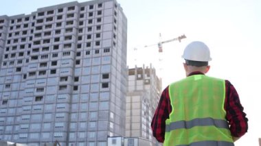 İnşaat alanındaki Mühendislik Danışmanlığı elinde planları tutuyor. İnşaat müfettişi