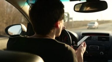 Araba süren ve araba kullanırken telefon kullanan bir adam. Sohbet ve araba kullanma. Telefondaki ses mesajı