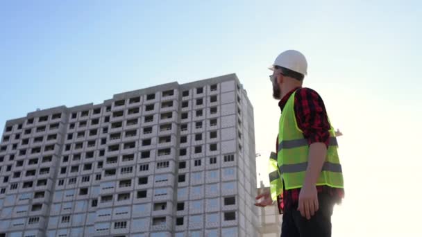 Engenheiro de construção supervisiona o processo. construtor masculino, construtores, engenheiro andando ao longo dele — Vídeo de Stock