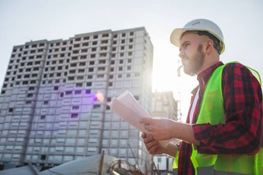 İnşaat alanında mavi baskı ile çalışan mühendis ya da mimar konsepti