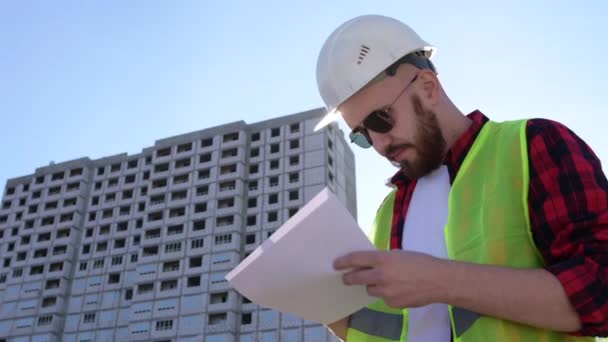 Inżynier budowlany sprawdza prace związane z komunikacją z kierownictwem na placu budowy — Wideo stockowe