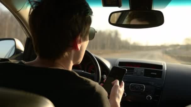 スマートフォンの携帯電話の運転を使用して手を握る人の手を閉じる車の黒い画面に触れるぼやけた背景をタップ — ストック動画