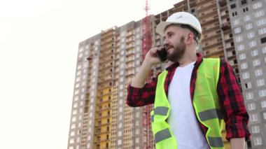  İnşaat alanında çalışan akıllı telefonlu bir mühendisin portresi.. 