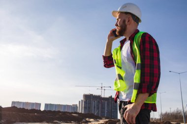  İnşaat alanında çalışan akıllı telefonlu bir mühendisin portresi.. 