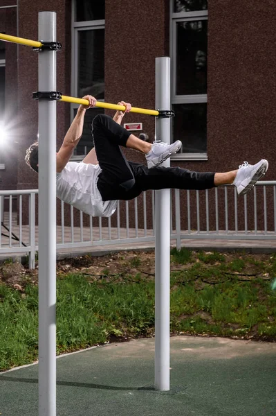 Muscular man during his workout on the street with horizontal bar — Stock Photo, Image