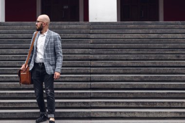 Zarif resmi takım elbiseli yakışıklı erkek pazarlama uzmanları şehir caddesinde yürüyorlar ve konferansa gidiyorlar.