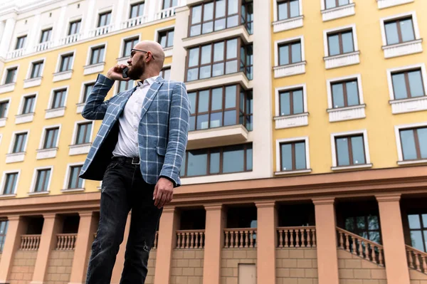 Бизнесмен в костюме на фоне красивого здания разговаривающего по телефону. открытый — стоковое фото