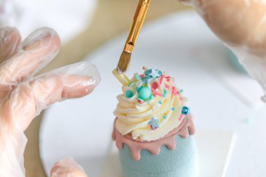 Pasta şefi pastayı süslüyor. Çeşitli mini kekler tatlı tatlı