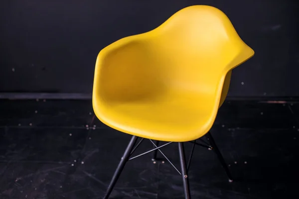 Cadeira amarela moderna na sala preta interior piso de madeira parquet — Fotografia de Stock