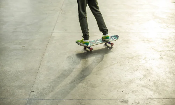 Een jongen rijdt op een skateboard met camouflage schuurpapier in een skatepark. Leeg het betonnen oppervlak — Stockfoto