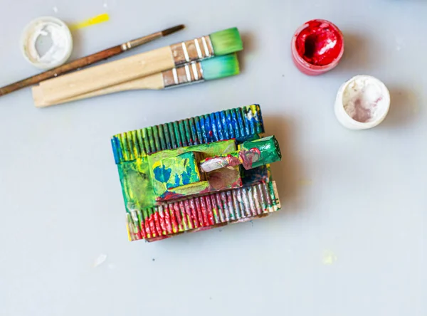 Niño haciendo tanque de juguete con sus propias manos, pinta un tanque de cartón con gouache. Ocio creativo interior para niños. Apoyando la creatividad, la artesanía. La clase maestra del arte en el día del hombre 23 febrero Fotos de stock libres de derechos