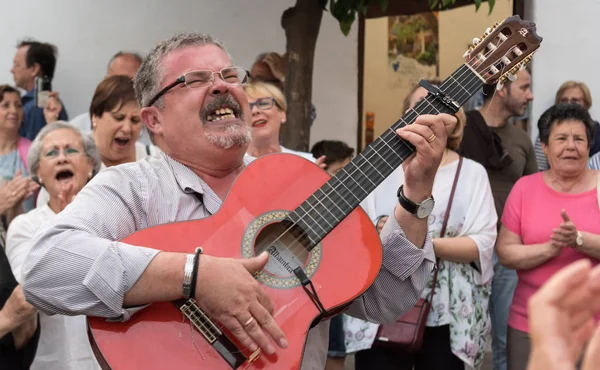 9 Mayıs 2017 'de Cordoba' daki festival verandasında halk korosu konserinde orta yaşlı bir adam halk şarkıları söylüyor ve gitar çalıyor..