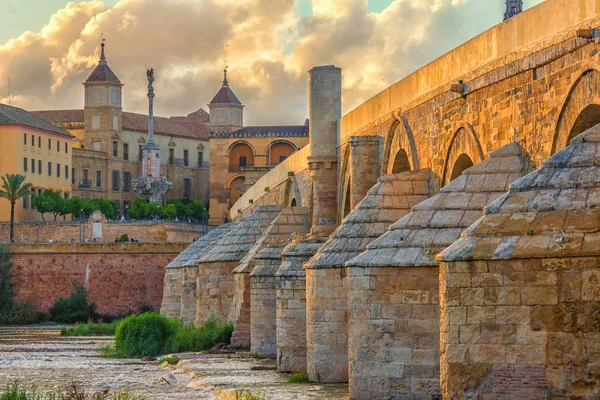 Roma Köprüsü (Puente Romano), Cordoba, İspanya. Günbatımında bulutlu bir gökyüzü olan Torre Calahorra 'dan güzel bir Roma Köprüsü..