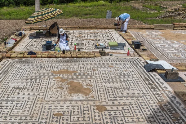 Santiponce (Sevilla), İspanya, 4 Mayıs 2017. Restoratörler antik Roma şehri Italica 'nın kalıntılarındaki mozaiği restore ettiler.