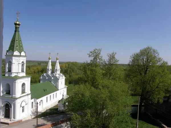修道院中庭と緑の屋根を持つ教会の白い建物の周りの要塞レンガの壁の高さからの眺め — ストック写真