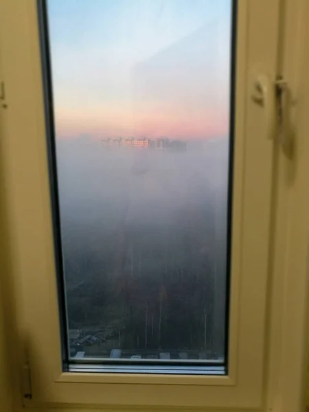 Туман Снаружи Однолистного Пластикового Окна Освещенного Малиновым Рассветом — стоковое фото