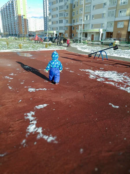 Mavi Tulumlu Küçük Bir Çocuk Kırmızı Kaplamalı Bir Oyun Parkında — Stok fotoğraf